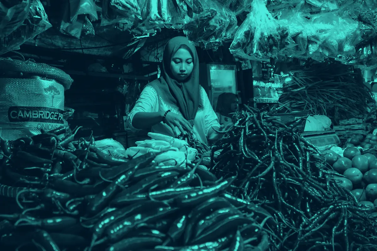 Pedagang perempuan berjilbab di lapak sayur dan cabai